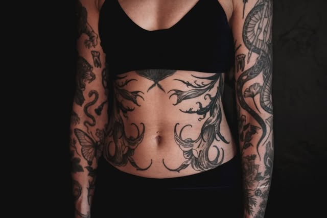 Tattoo compositions across a torso and both arms